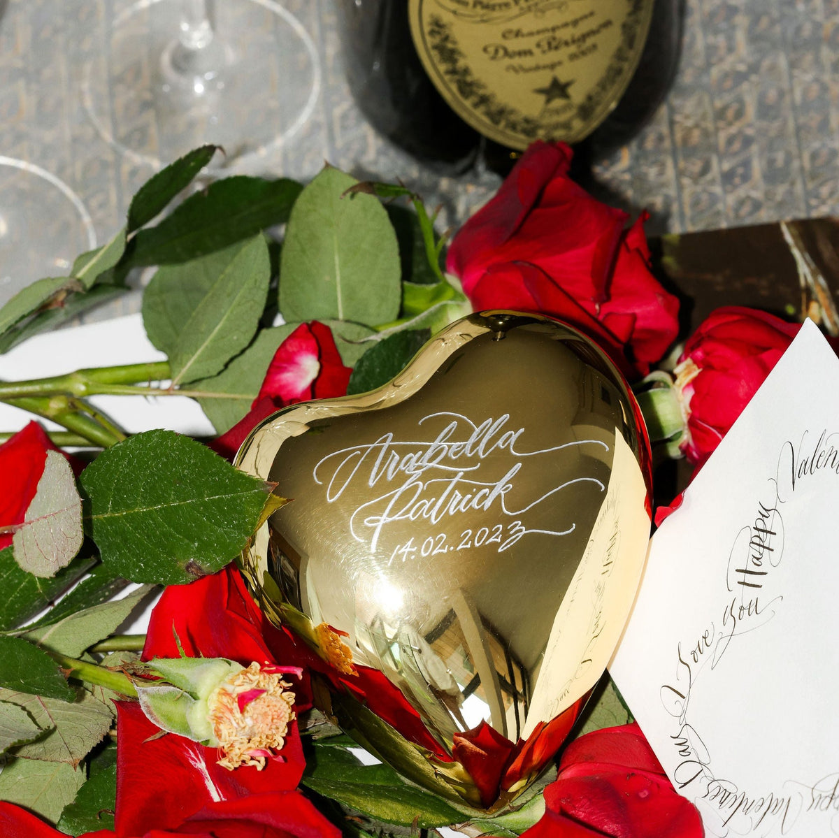 Gold-dipped crystal heart hand-engraved with a couple's names and wedding date among red roses