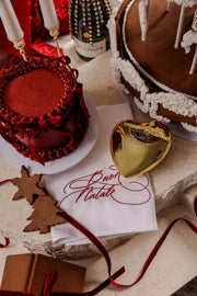 Embroidered Christmas napkin reading Buon Natale on a festive Christmas table