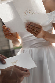 Bride and groom reading his and her calligraphy vow books
