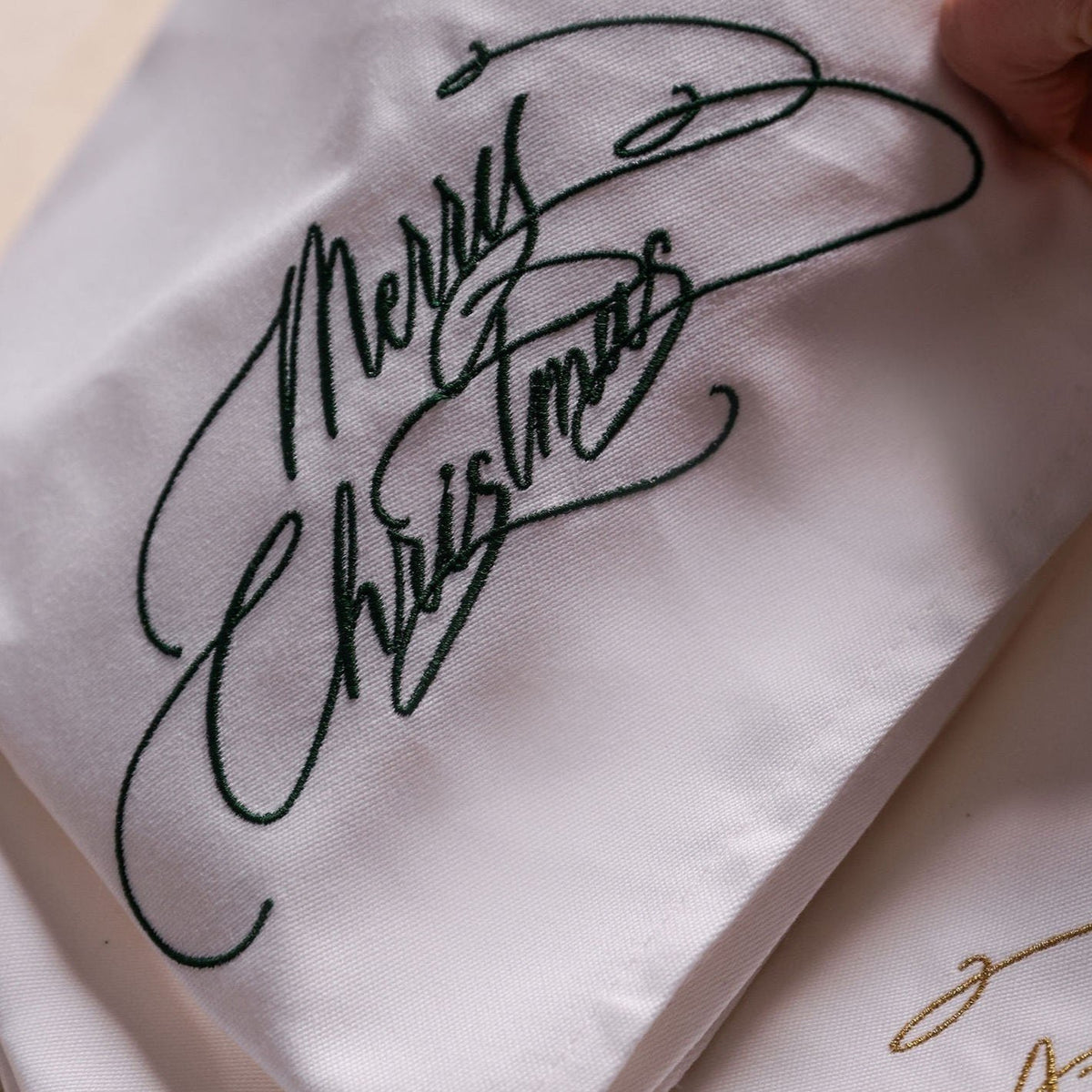 Merry Christmas embroidered napkin in forest green calligraphy