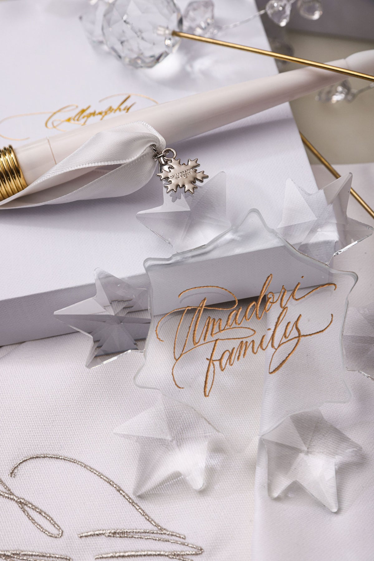 Year charm attached to a family name crystal snowflake ornament