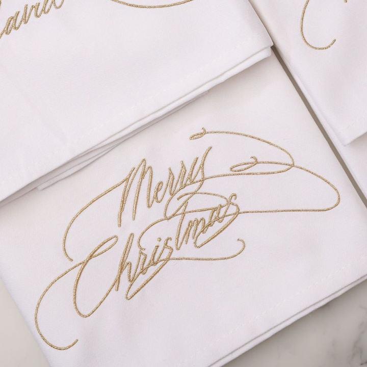 Merry Christmas embroidered napkin in metallic gold calligraphy