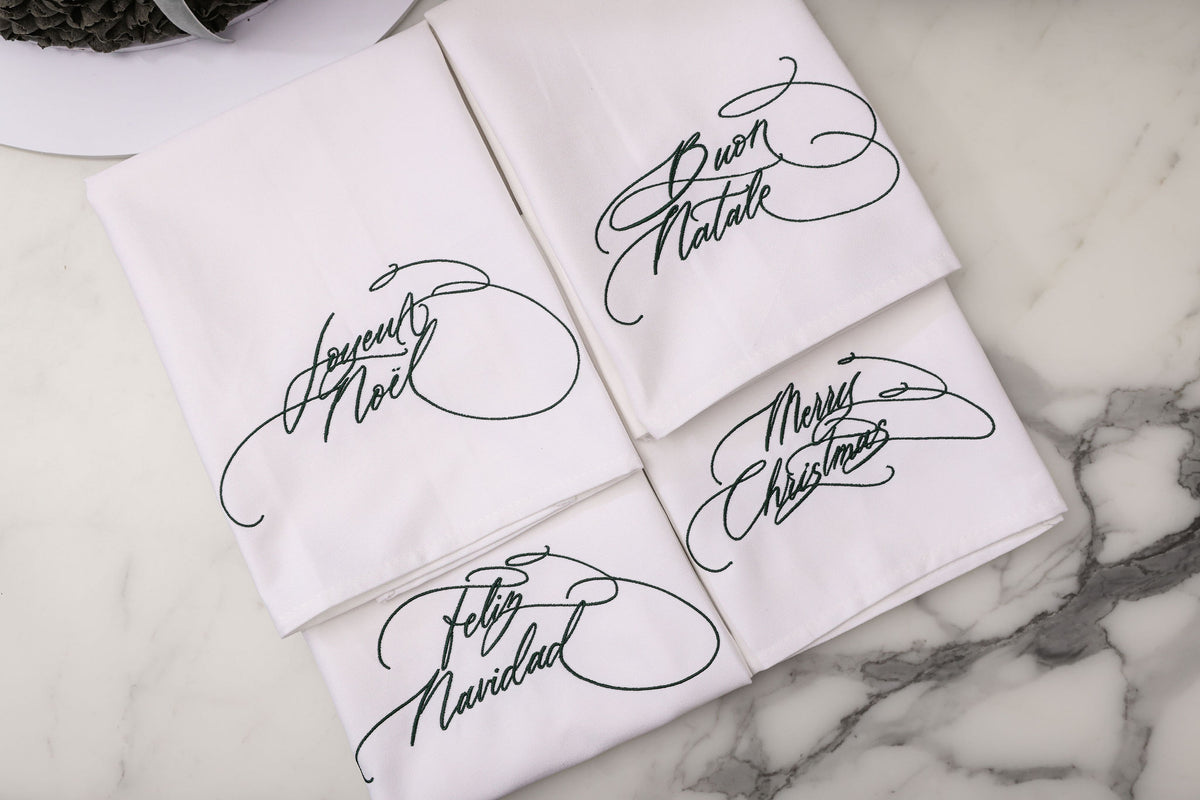 Embroidered Christmas napkins in forest green: Merry Christmas, Buon Natale, Joyeux Noël and Feliz Navidad