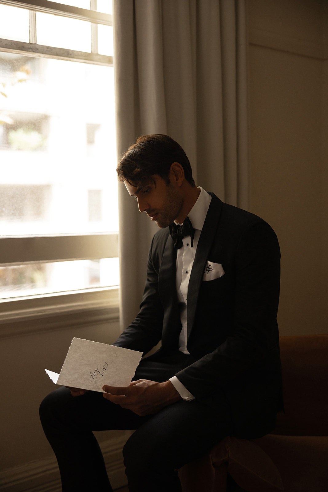 Groom reading his calligraphy vow book before the wedding ceremony