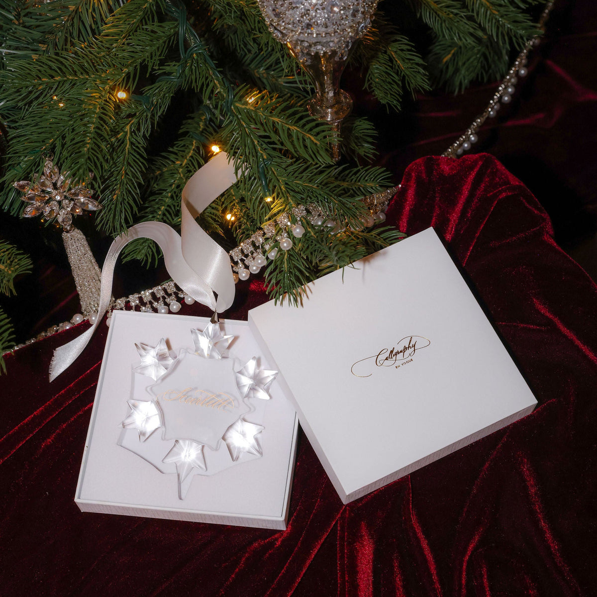 Opulent snowflake ornament in its luxury white gift box under the Christmas tree