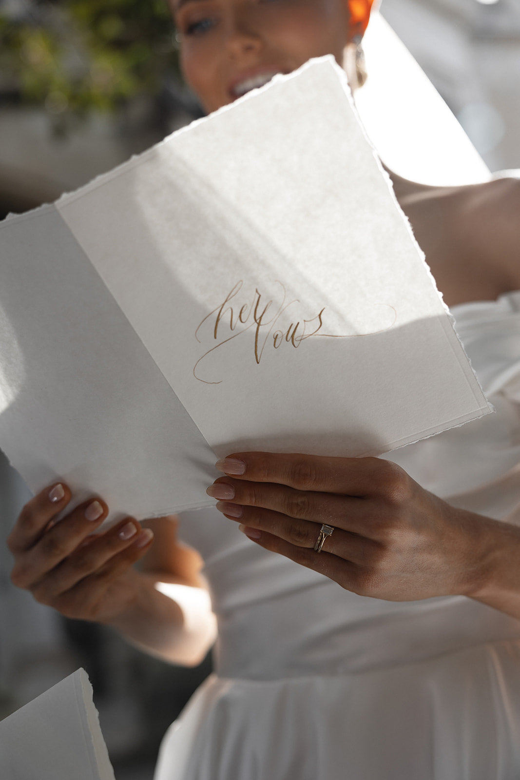 Bride reading her handwritten calligraphy vow book
