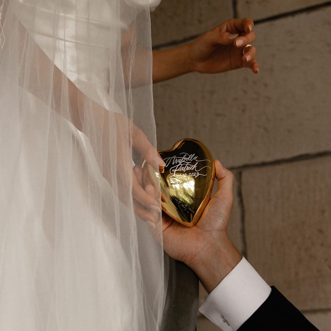 Bride holding an engraved gold crystal heart keepsake on her wedding day