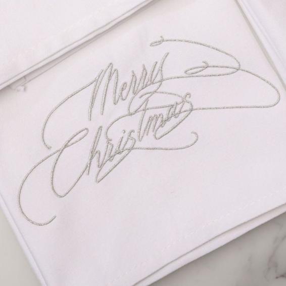 Merry Christmas embroidered napkin in metallic silver calligraphy