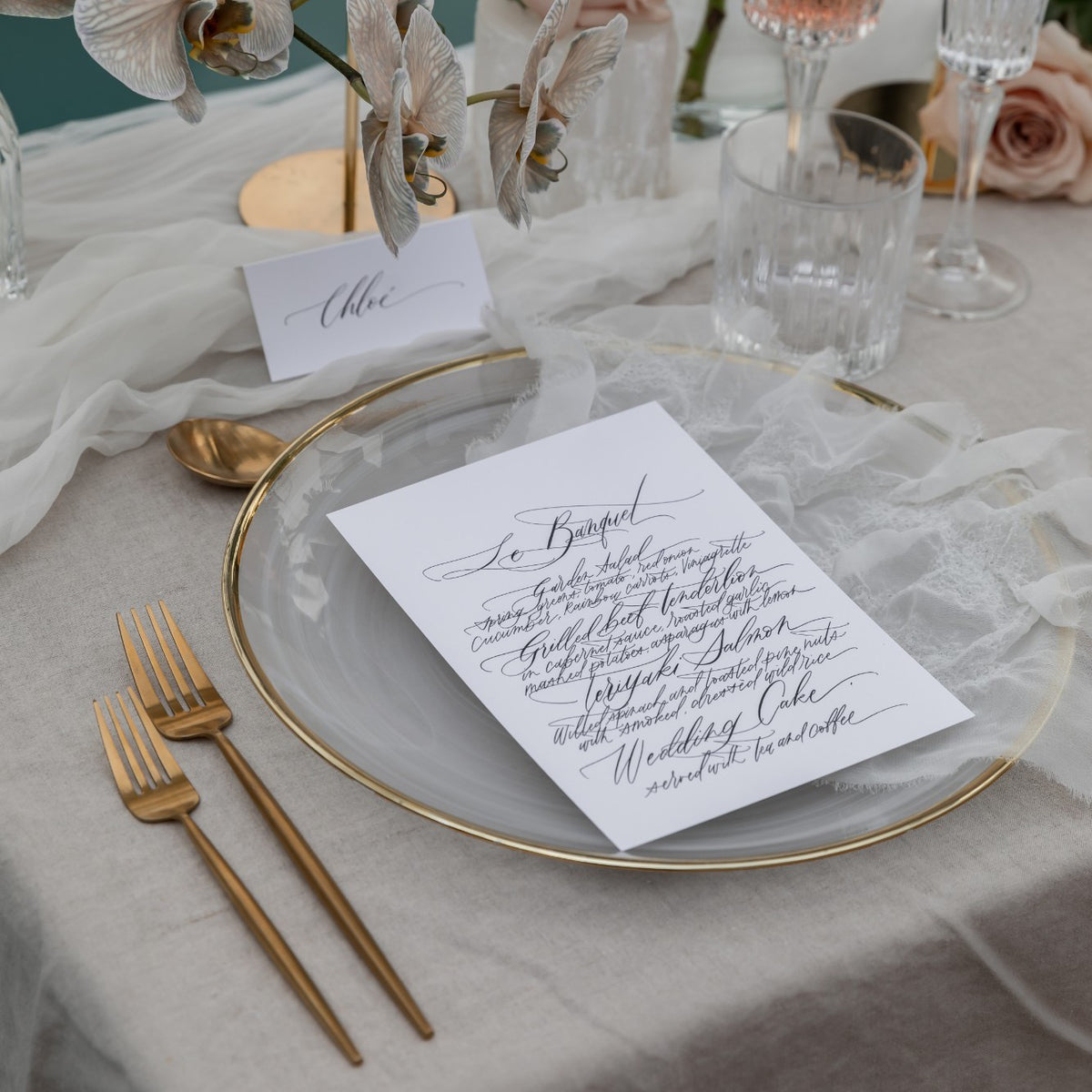Calligraphy wedding menu and matching place card on a table setting