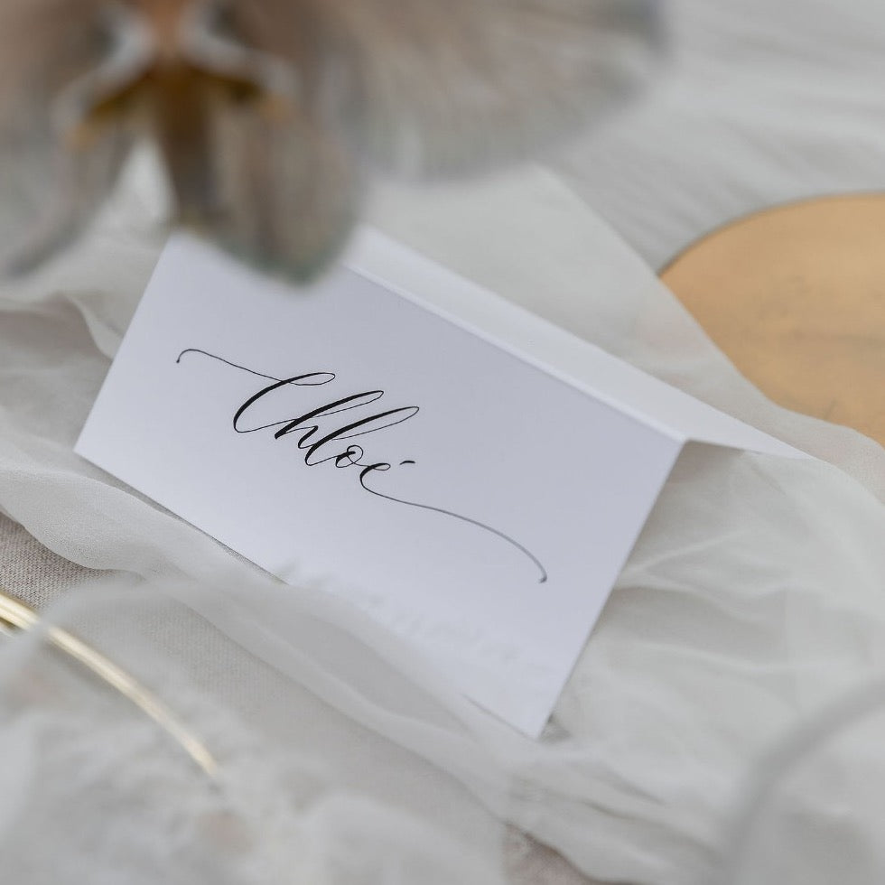 Signature style hand calligraphy place card on a wedding table