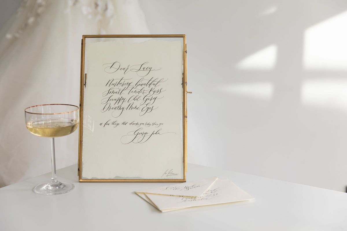Framed handwritten calligraphy love letter with a champagne glass