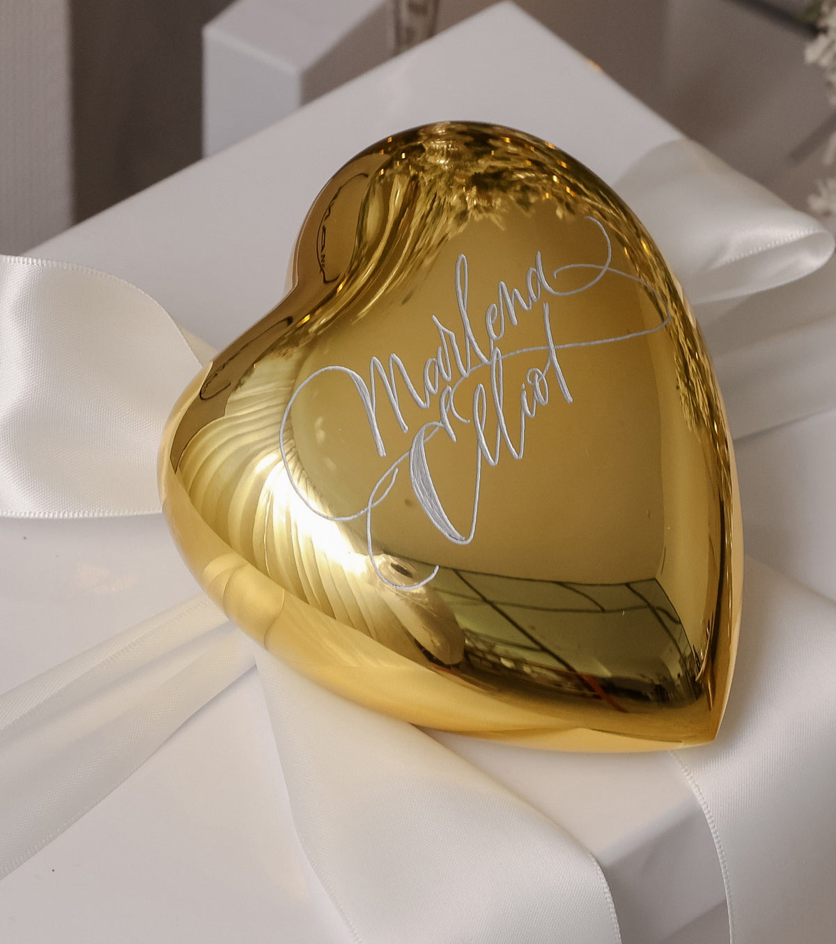 Engraved crystal heart with names in calligraphy on a white satin gift box