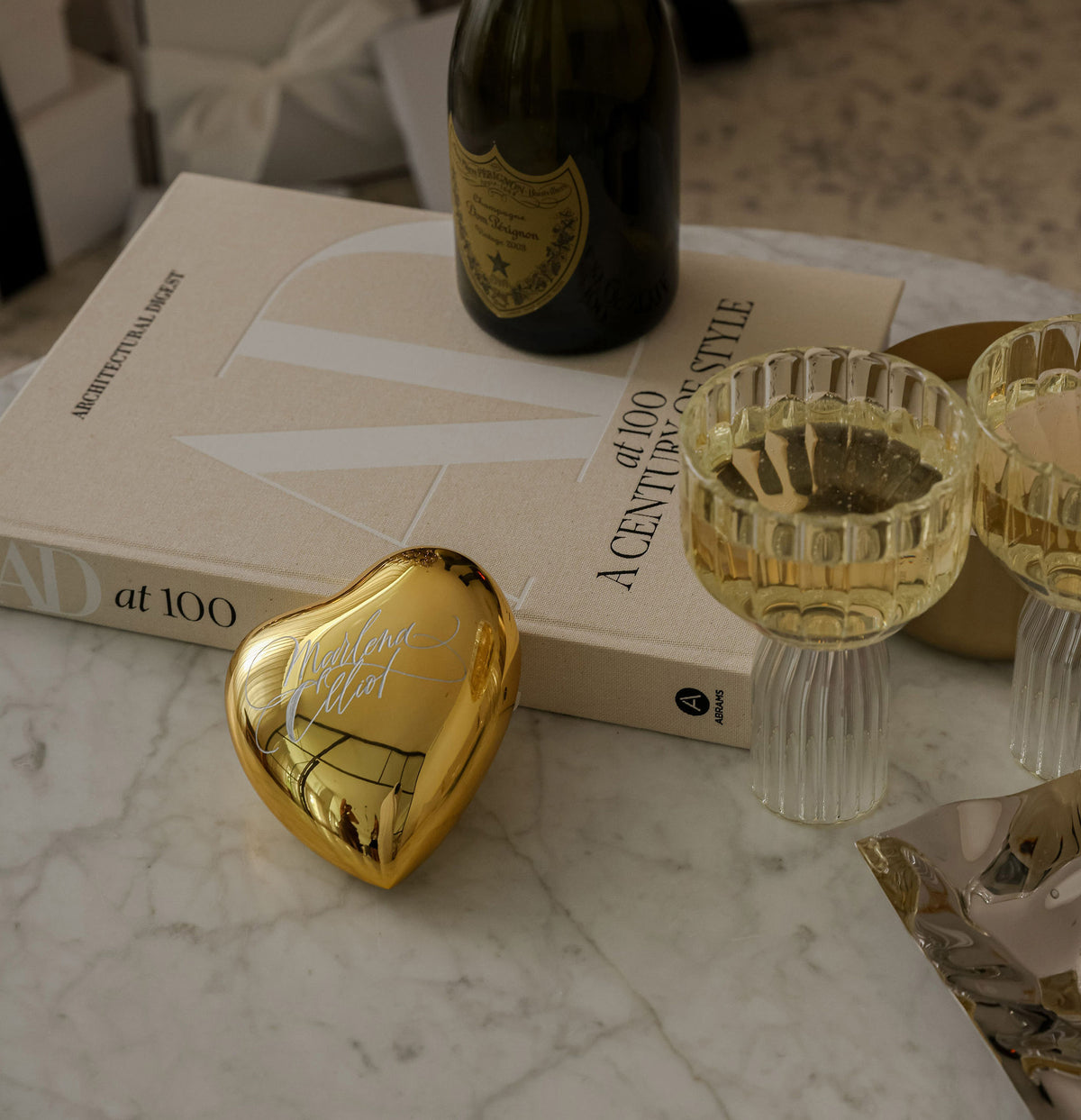 Gold engraved crystal heart on a coffee table with champagne